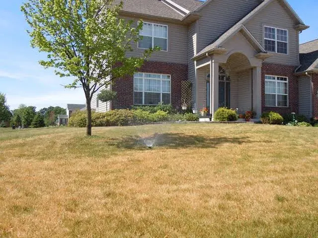 A property with a patchy, worn lawn